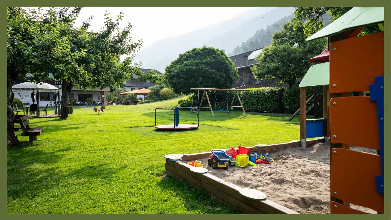 Ampio parco giochi con sabbiera, altalene e struttura per arrampicata presso la tenuta della famiglia Burgstaller sul lago di Millstatt in Carinzia.