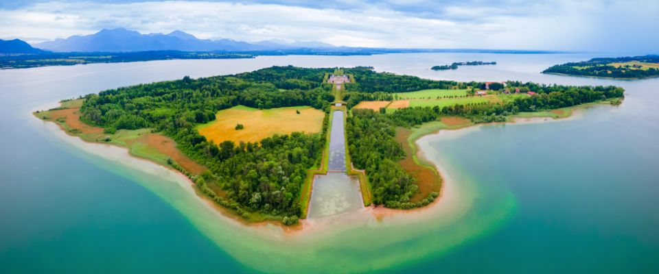 Kmetija ob jezeru Chiemsee pred Chiemgauskimi Alpami