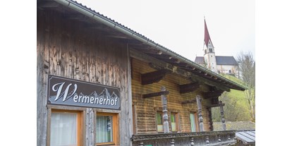 Urlaub auf dem Bauernhof - Fahrzeuge: Mähwerk - Penningberg - Aussenansicht mit Bliick auf Kirche St. Pankraz - Wermenerhof