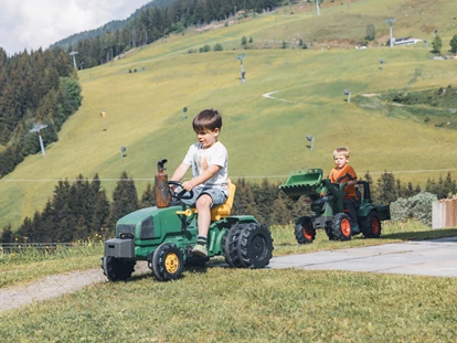 Urlaub auf dem Bauernhof - Brötchenservice - Obsmarkt - Rund ums Haus gibt es allerlei Spielmöglichkeiten für Kinder: Zahlreiche Tretfahrzeuge wie Traktoren, GoKarts oder Fahrräder stehen zur Verfügung - Ferienwohnungen Perfeldhof