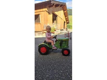 vacanza in fattoria - Fahrzeuge: Futtermischwagen - Putschall - Antonia mit einem der zahlreichen Tretfahrzeuge - Ferienwohnungen Perfeldhof