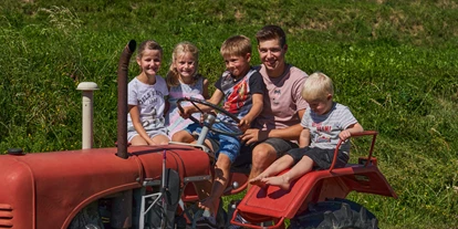 dovolená na farmě - Rodeln - Alpen - Fahrt mit dem kleinen roten Traktor - Bauernhof Leneler