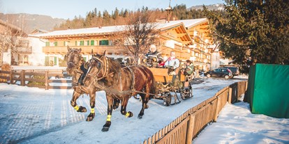 Urlaub auf dem Bauernhof - nachhaltige Landwirtschaft - Tirol - Unsere Norika - Pferde ziehen im Winter den großen Schlitten durch die verschneite Landschaft. - Familotel Landgut Furtherwirt