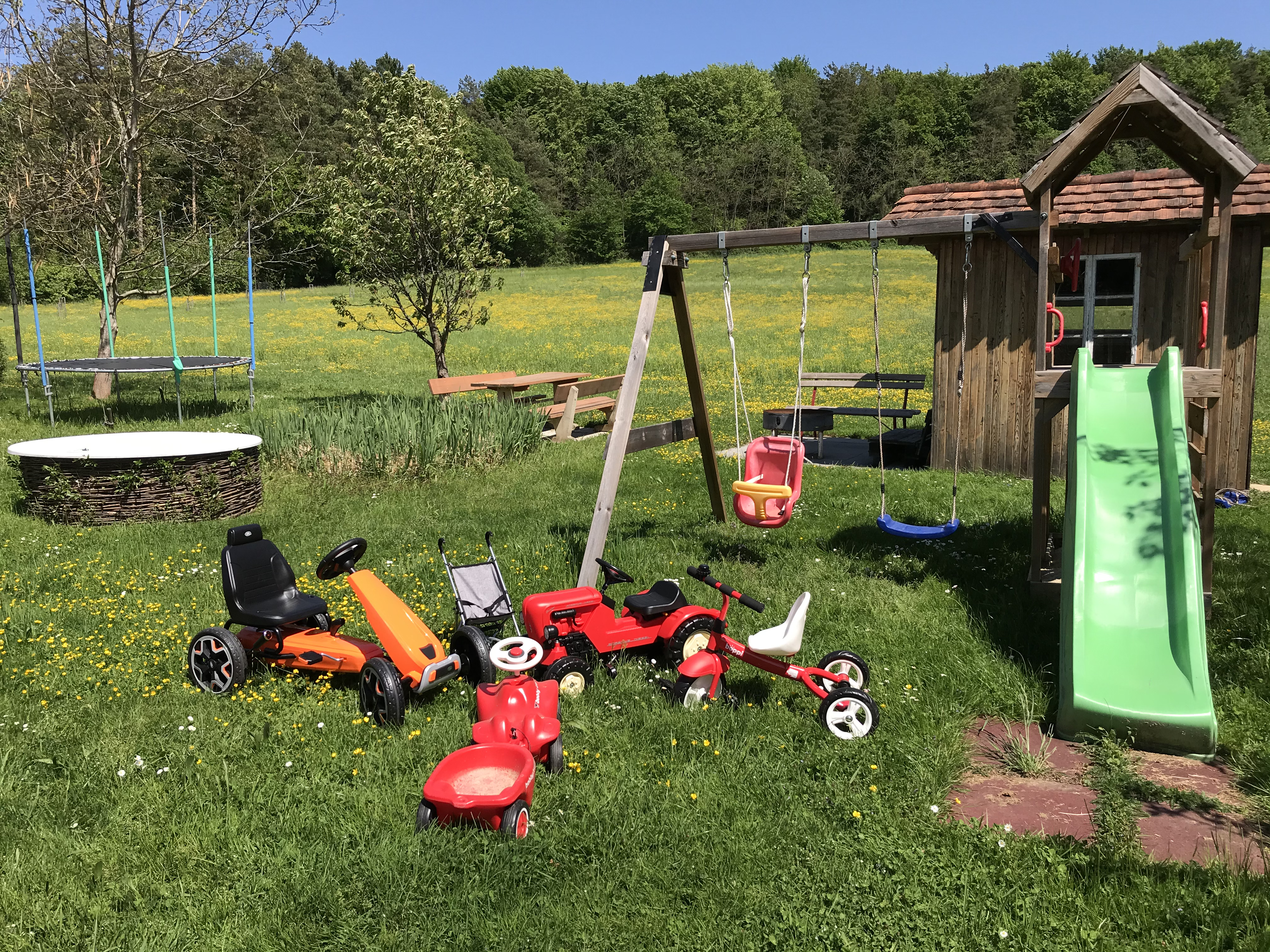 Unterkunft: Spielgeräte und Rutsche sowie ein Spielhäuschen für Kinder in einer grünen Umgebung - Wohnung Familienglück