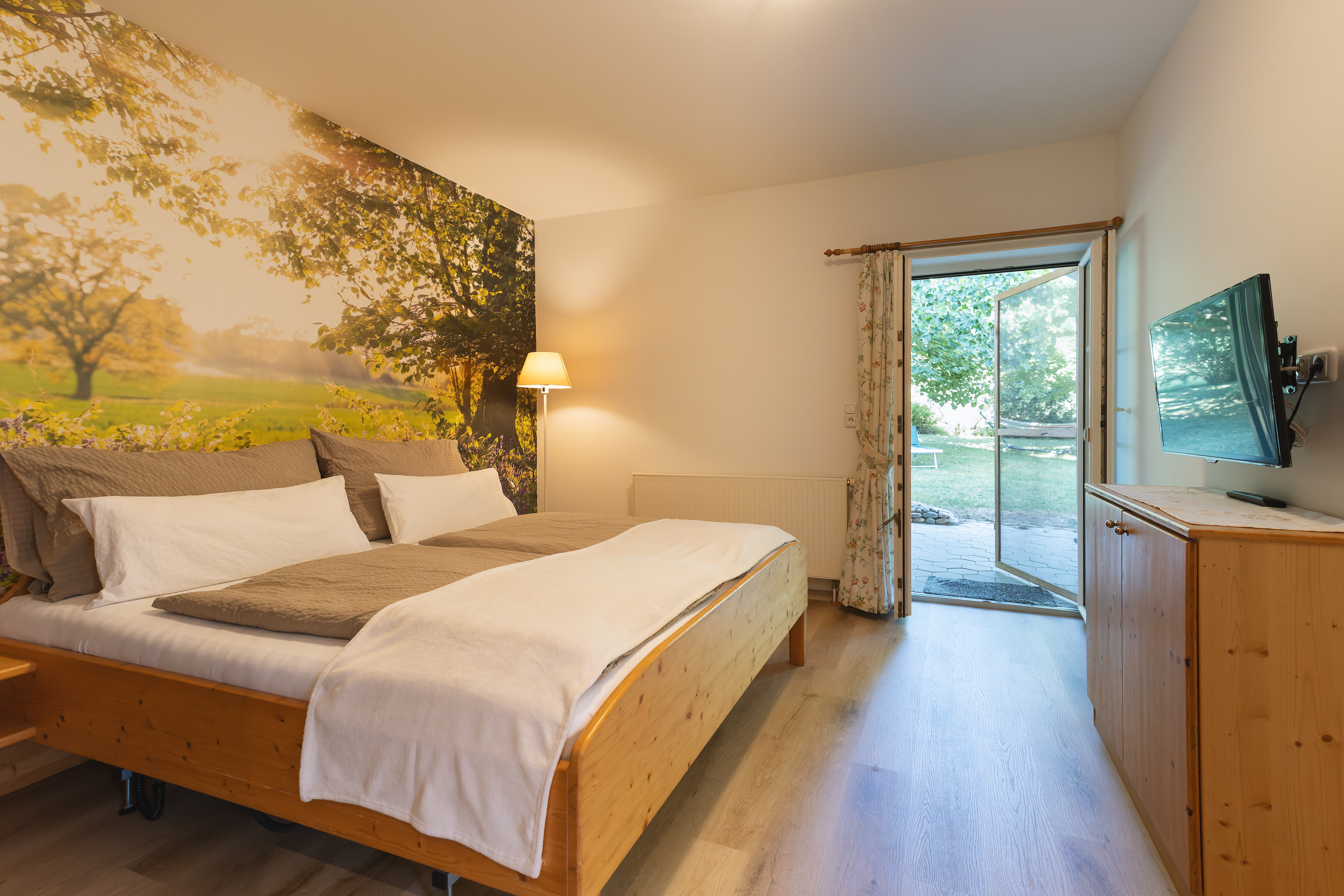 Unterkunft: Schlafzimmer mit Doppelbett aus Holz mit Zugang zur schönen Terrasse - Wohnung Gartenlust - barrierefrei