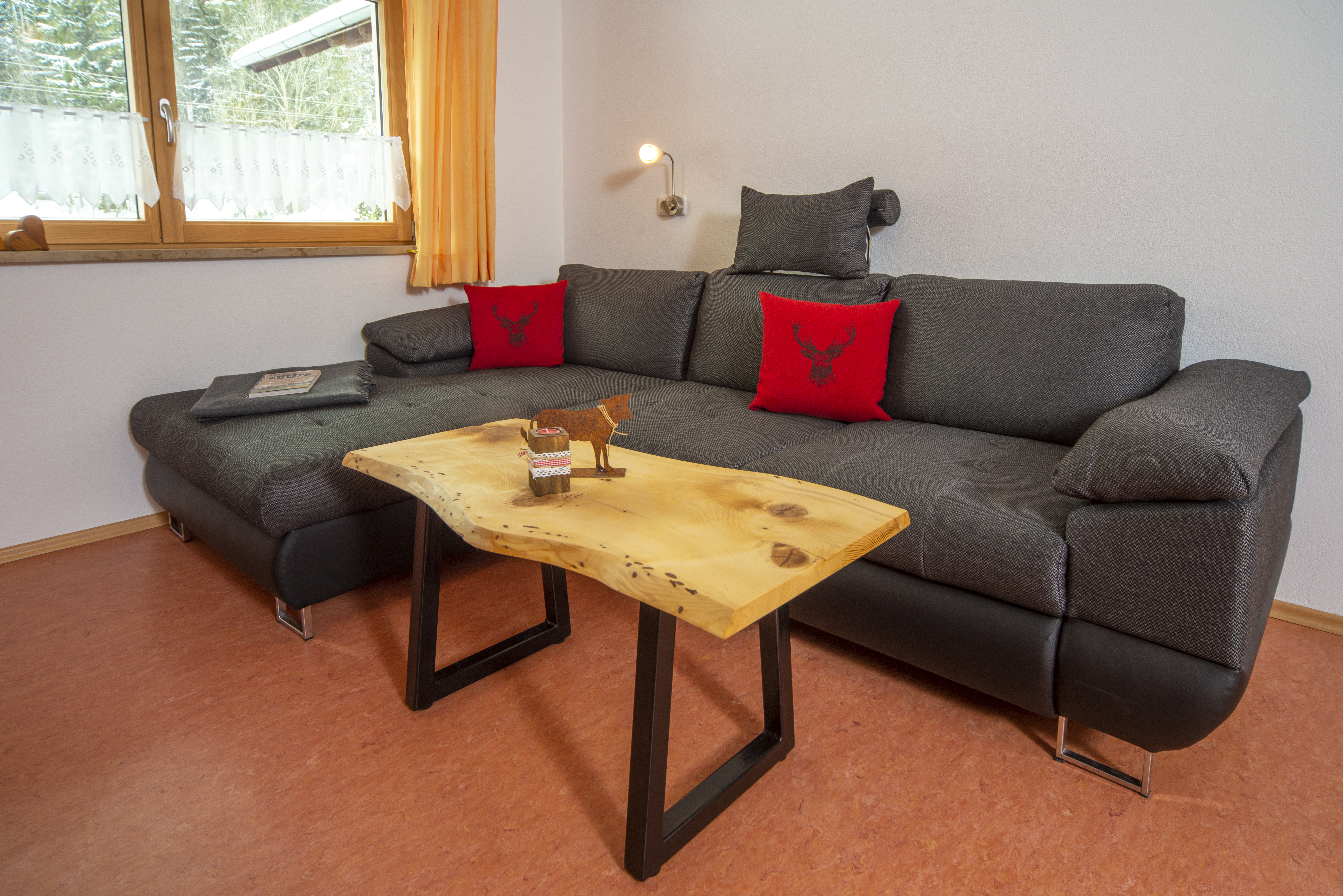 Unterkunft: Gemütlicher Wohnbereich mit bequemer Couch, Fernseher, Büchern und Spielen - Ferienwohnung Löwenzahn