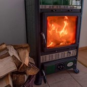 Angebote-Urlaub-am-Bauernhof: warmer Kaminofen in der gemütlichen Ferienwohnung - Rauhe Ostsee und warmes Kaminfeuer