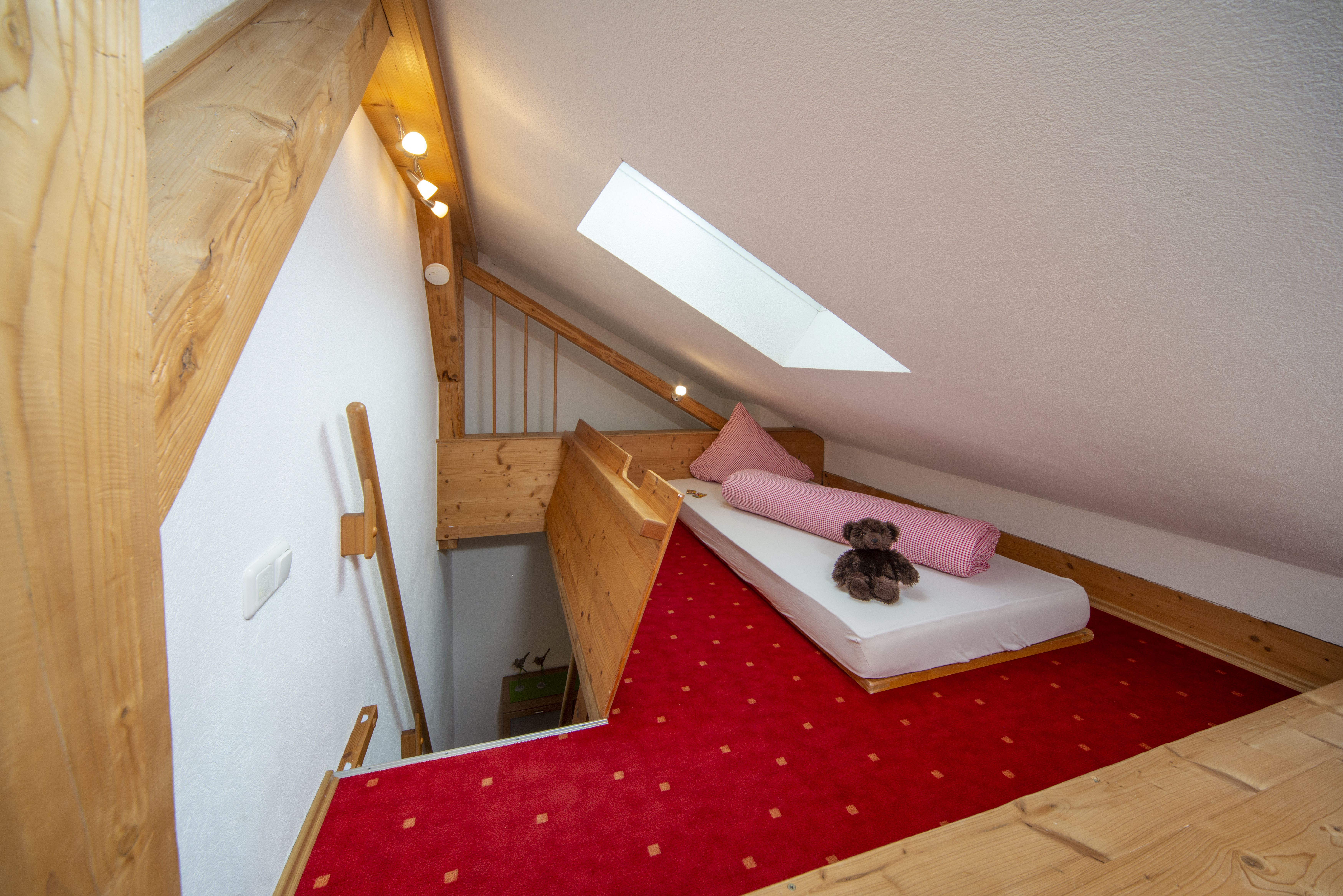 Ferien Bauernhof: Ferienwohnung Löwenzahn: Kinder- und Teeneparadies – Unsere Ferienwohnung Löwenzahn bietet einen gemütlichen Rückzugsort mit Fallklappe für Kinder und Jugendliche zum Träumen, Lesen und Spielen.
Gemütliches Schlafreich für Kinder mit Kuschelecke, Abschließbares Dachfenster - Ferienhof Nägele