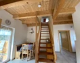 Ferien Bauernhof: Über eine Treppe geht es hinauf ins offene Obergeschoss. Ein Schlafzimmer mit Doppelbett befindet sich im Erdgeschoss. - NaturGut Kunterbunt 