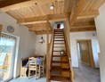 Ferien Bauernhof: Über eine Treppe geht es hinauf ins offene Obergeschoss. Ein Schlafzimmer mit Doppelbett befindet sich im Erdgeschoss. - NaturGut Kunterbunt 